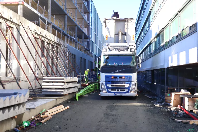 At det er trangt på byggeplassen er ingen hindring når fyllmassen kan blåses på plass med lange slanger (Foto: Jan Vestre)