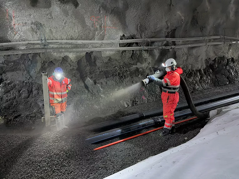 Leca® Lettklinker blåses på plass i Hestnestunnelen. Effektiv og presis utlegging sikrer god drenering og frostbeskyttelse rundt rørene i grøften. 