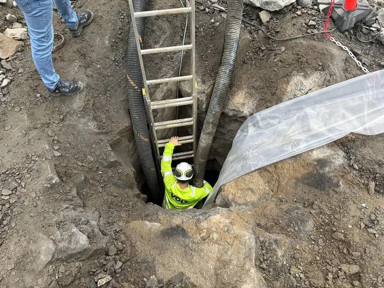 En av gutta fra Volt Entreprenør jobber seg ned flere meter under bakken og sørget for at Leca lettklinker blir forsvarlig plassert, selv i trange tunneler.