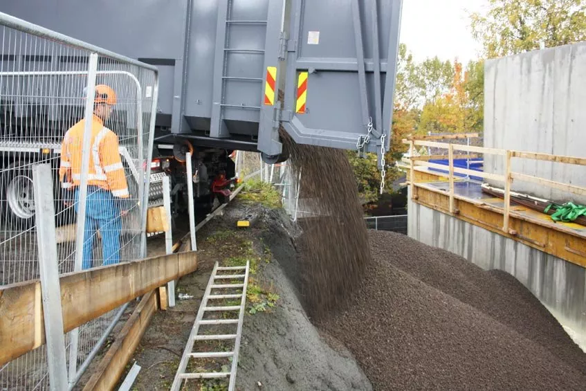 Leca Lettklinker tippes enkelt og greit ned i tomrommet mellom fjell og betongvegg.