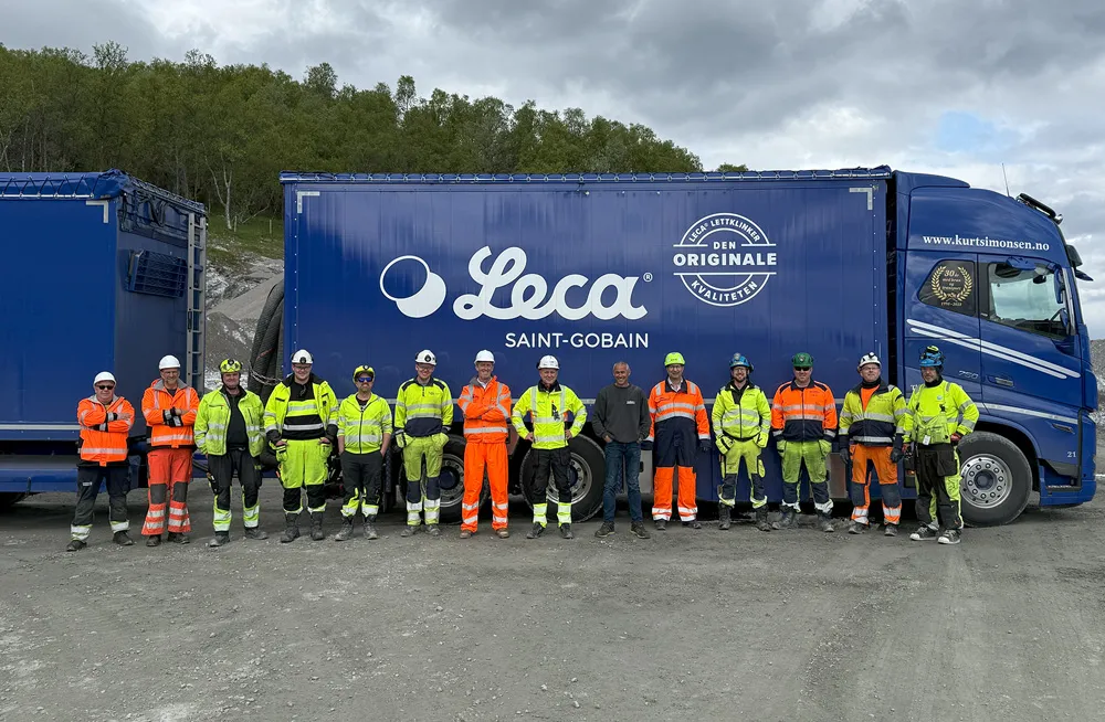 Gruppebilde av arbeidere og prosjektteamet foran blå Leca-blåsebil fra K. Simonsen Transport på anleggsområdet til Hålogalandsvegen.