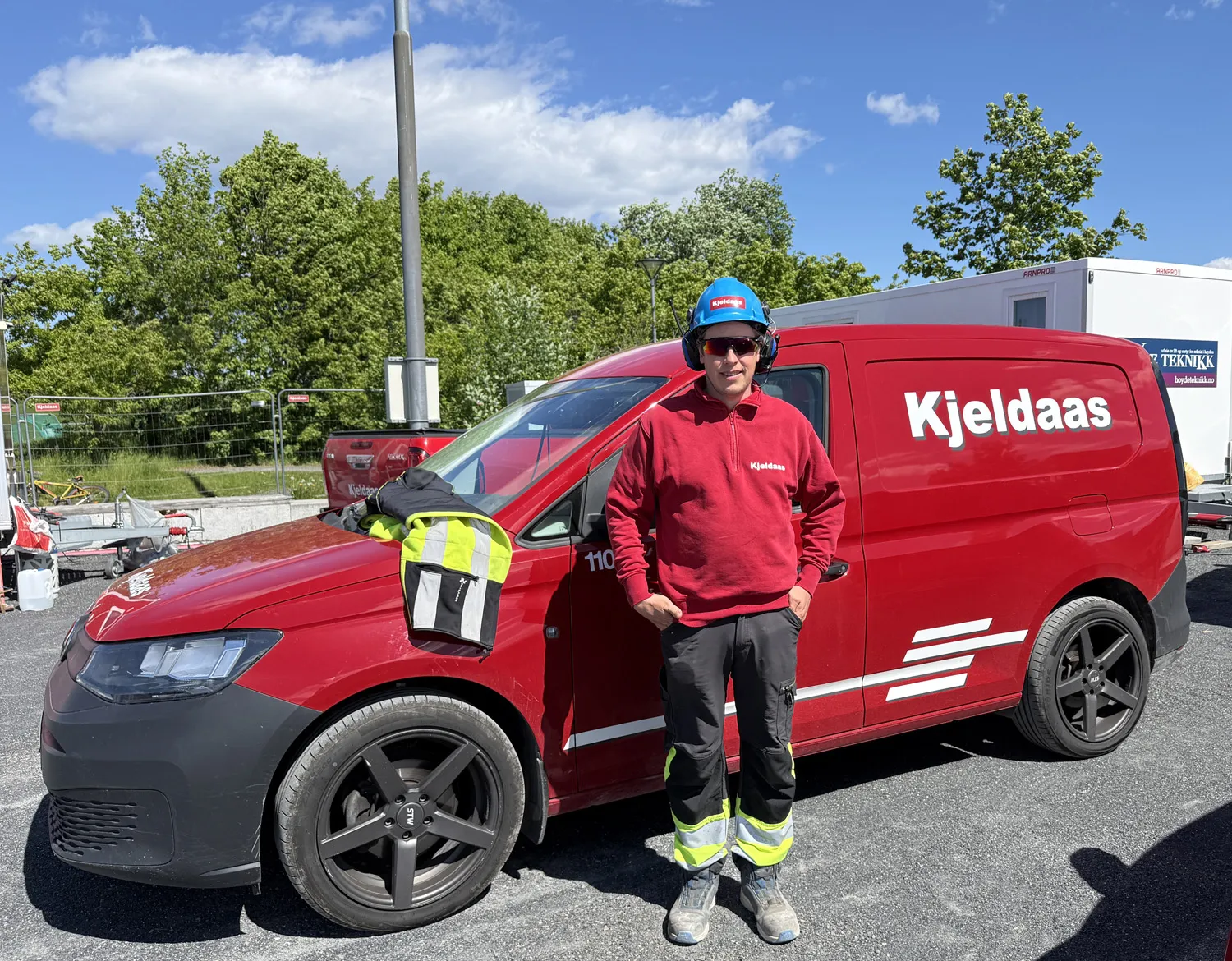 Ansatt fra Kjeldaas AS står foran firmabil på anleggsområdet på Fornebu.